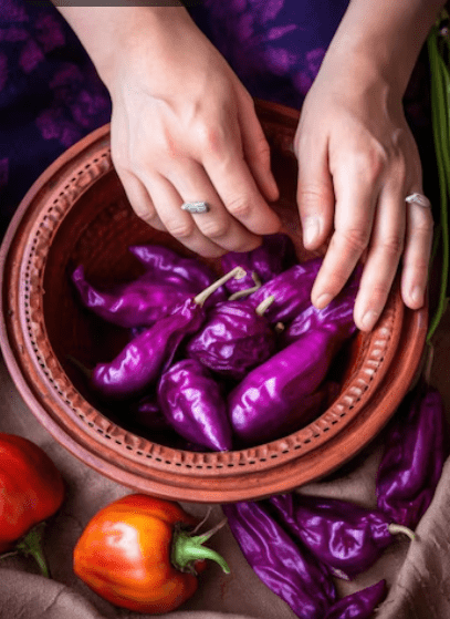 Closeup of hands and purple peppers in a bowl
