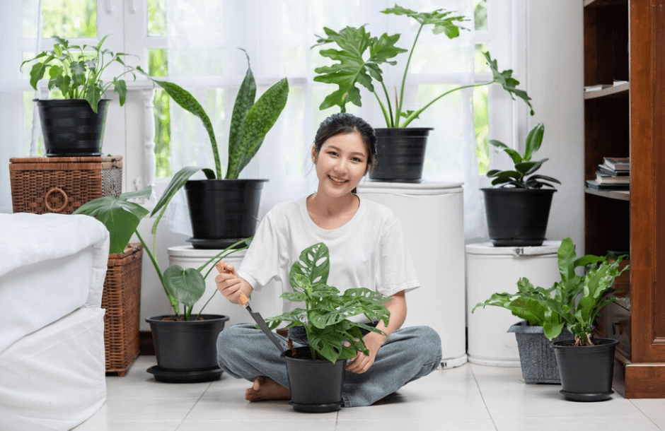 The woman is sitting and planting trees in the house