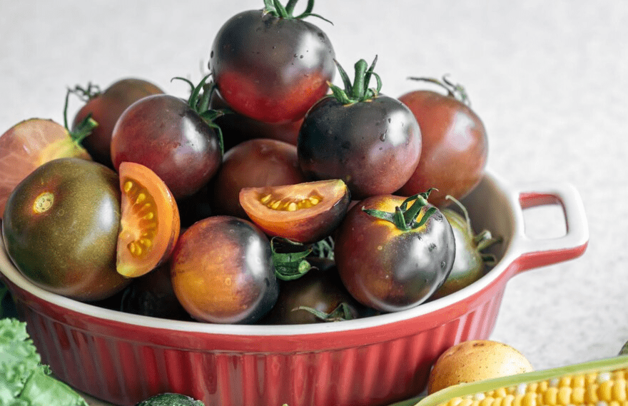 Closeup bowl with ripe black tomatoes on the kitchen table