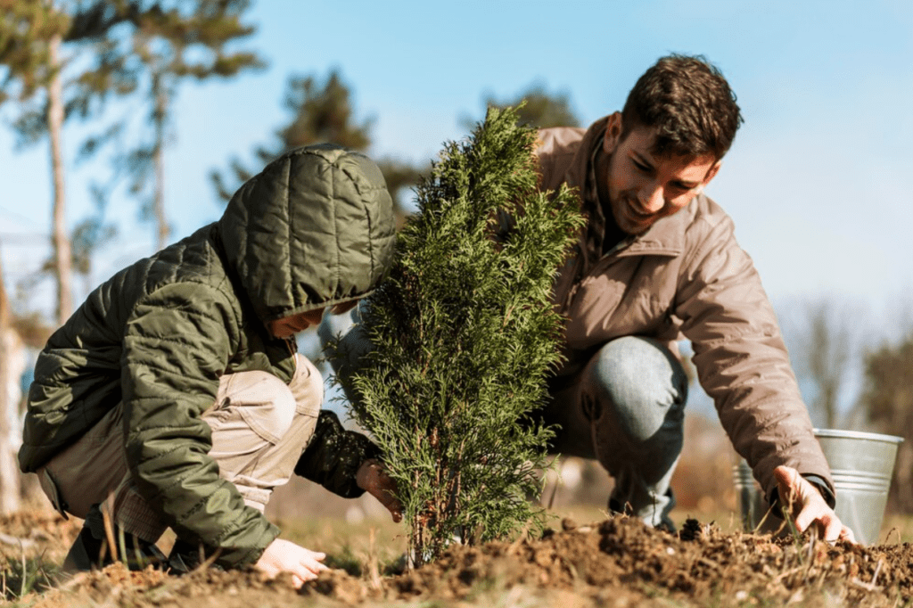 A father and son engage in tree planting, symbolizing growth and environmental stewardship in a vibrant outdoor environment.