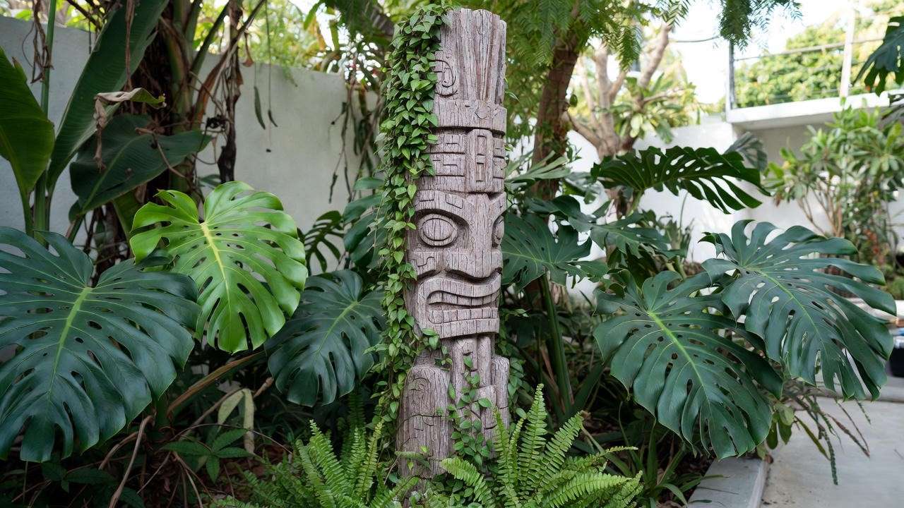 Custom tree fern fiber totem pole with climbing Monstera plants in a modern garden."