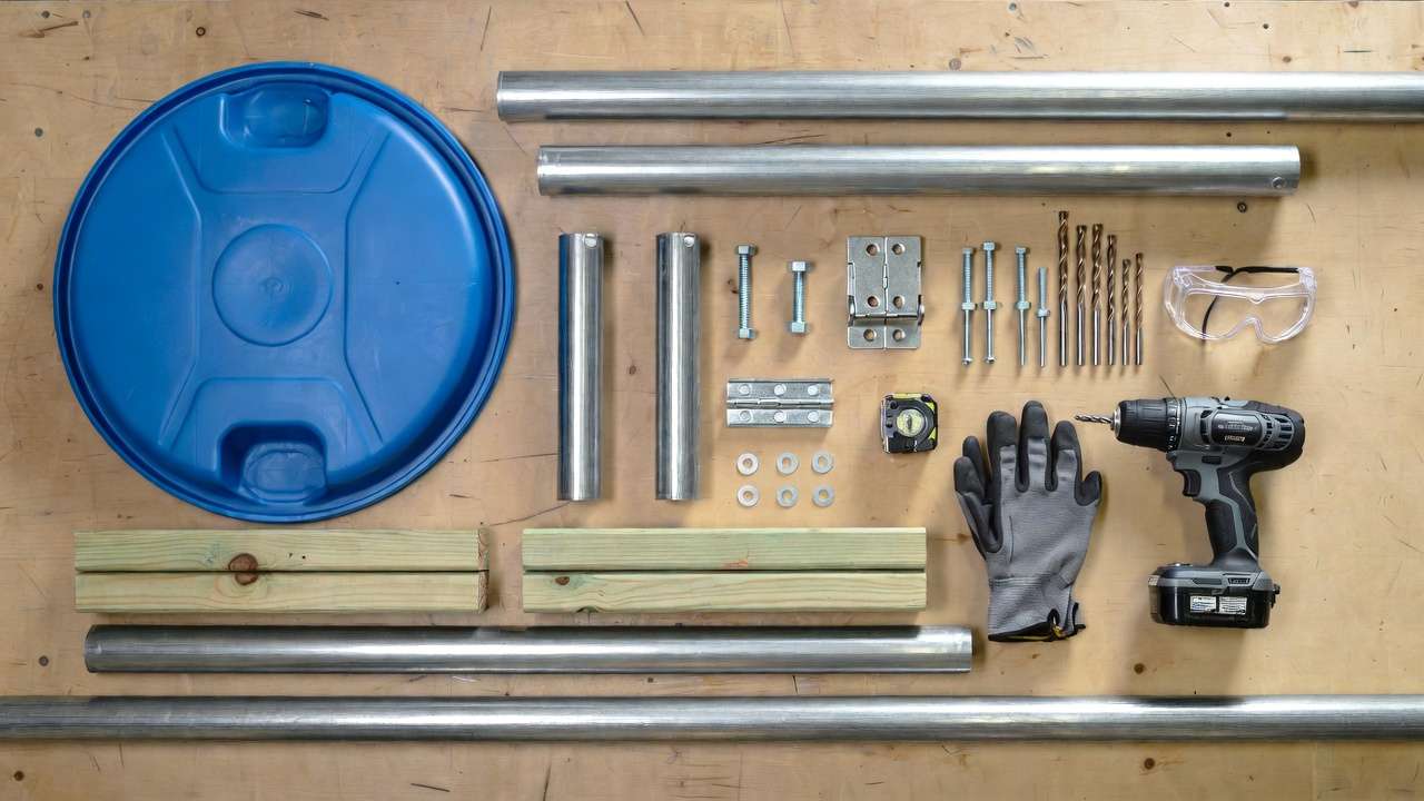 All materials and tools laid out for building a DIY backyard compost tumbler