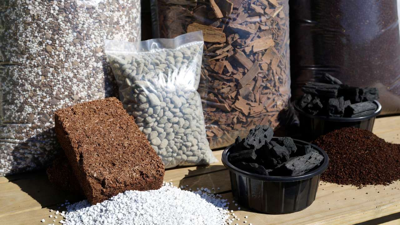 Bulk ingredients for creating customized houseplant soil mix including coco coir, perlite, pumice, orchid bark, charcoal, and worm castings.