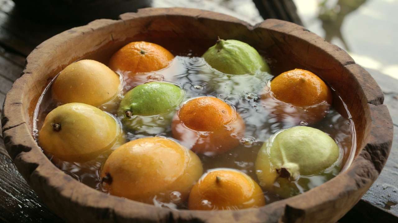 Washing and preparing homegrown mangoes guavas and citrus for orchard fruit gift baskets