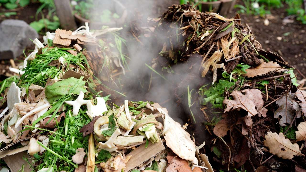 Homemade hot compost pile with layered organic materials in sustainable garden soil building