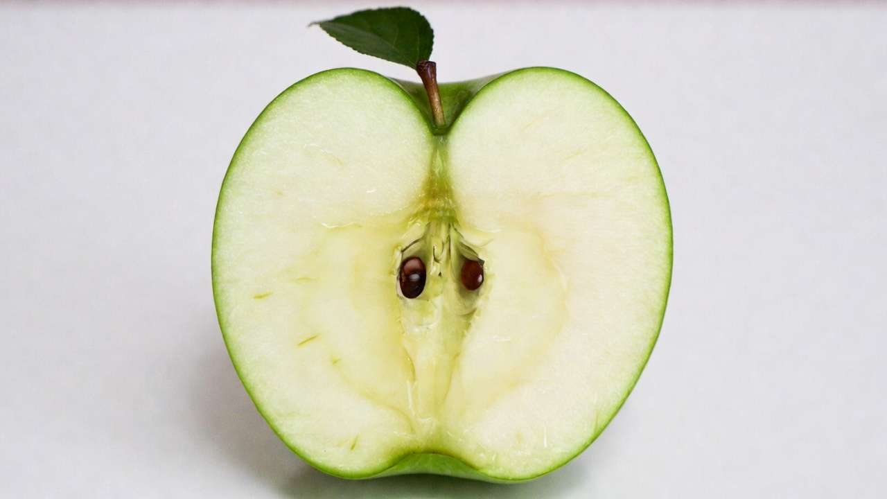 Cross-section of an apple revealing the central core with multiple seeds and accessory flesh.