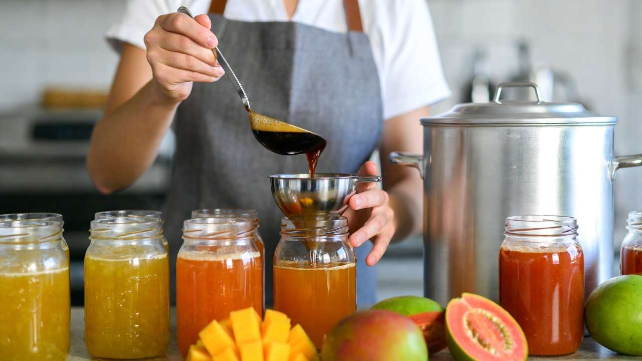 Home canning process filling jars with tropical fruit preserves safely
