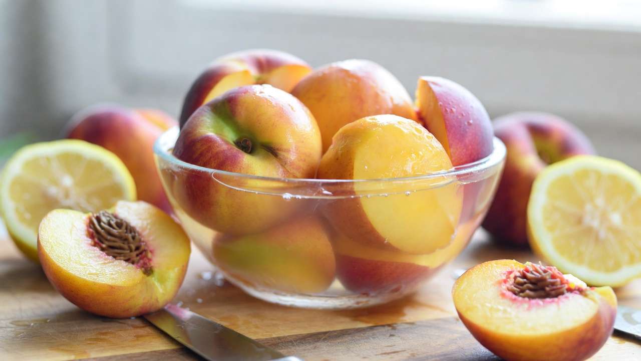 Peaches sliced and soaking in ascorbic acid to prevent browning before freezing or canning orchard fruit