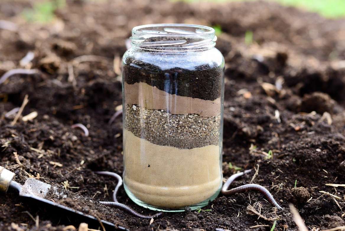 Soil jar test showing sand silt and clay layers for texture analysis