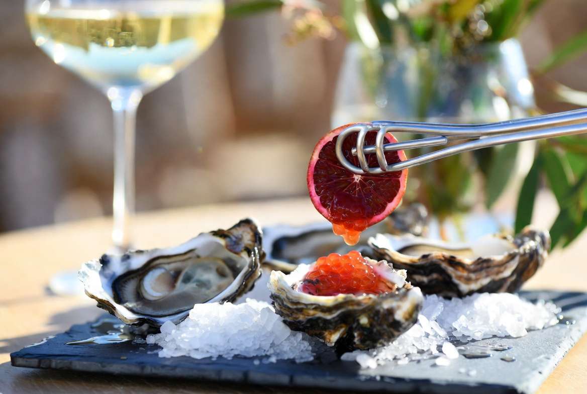 Fresh oysters garnished with shimmering red finger lime citrus caviar pearls.