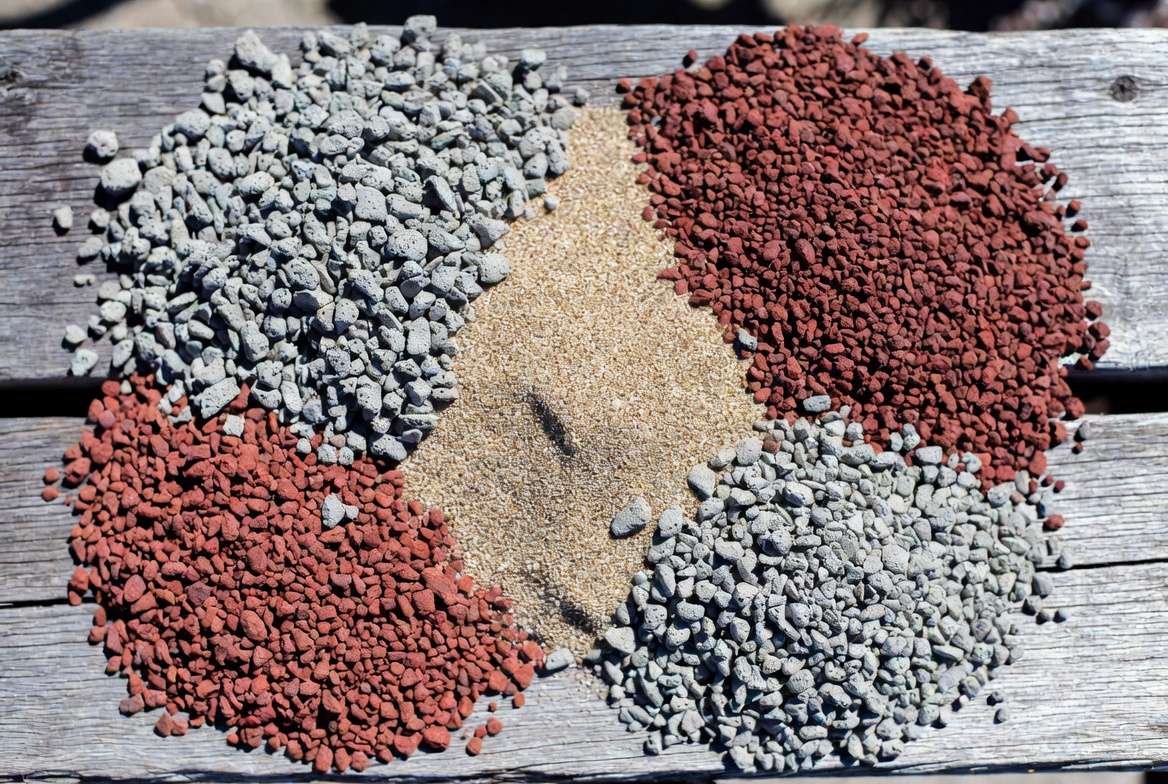 Piles of coarse grit, pumice, lava rock, and clay particles showing the ideal gritty substrate for preventing succulent rot.